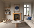 A contemporary solid oak fireplace surround in a minimalist design, with a visible fireplace and a seating area in a room with modern decor.