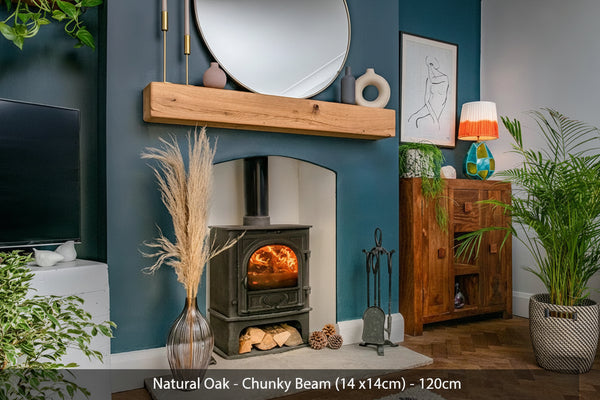 A natural oak fireplace beam with rounded edges, hanging on a blue wall above a fireplace, surrounded by decorative plants and furniture.