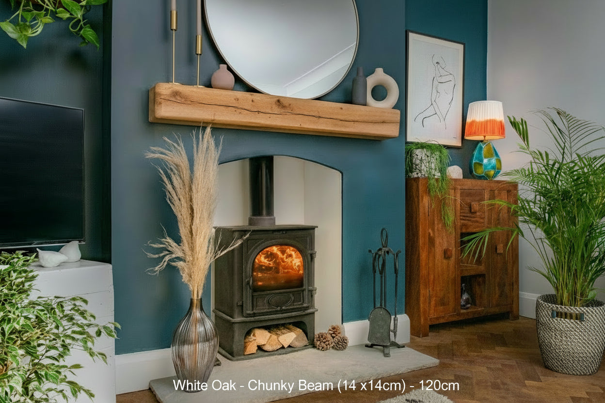 A natural oak fireplace beam mounted on a blue wall above a fireplace, with decorative items and a potted plant in the room.