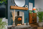 A rustic reclaimed wood fireplace beam mounted on a blue wall above a fireplace, with decorative plants and items in the room.