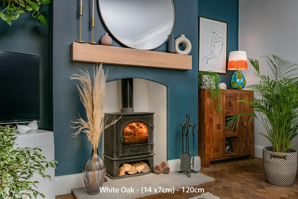 A contemporary clean lined white oak fireplace beam installed above a fireplace in a room with blue walls, wooden flooring, and various decorations.